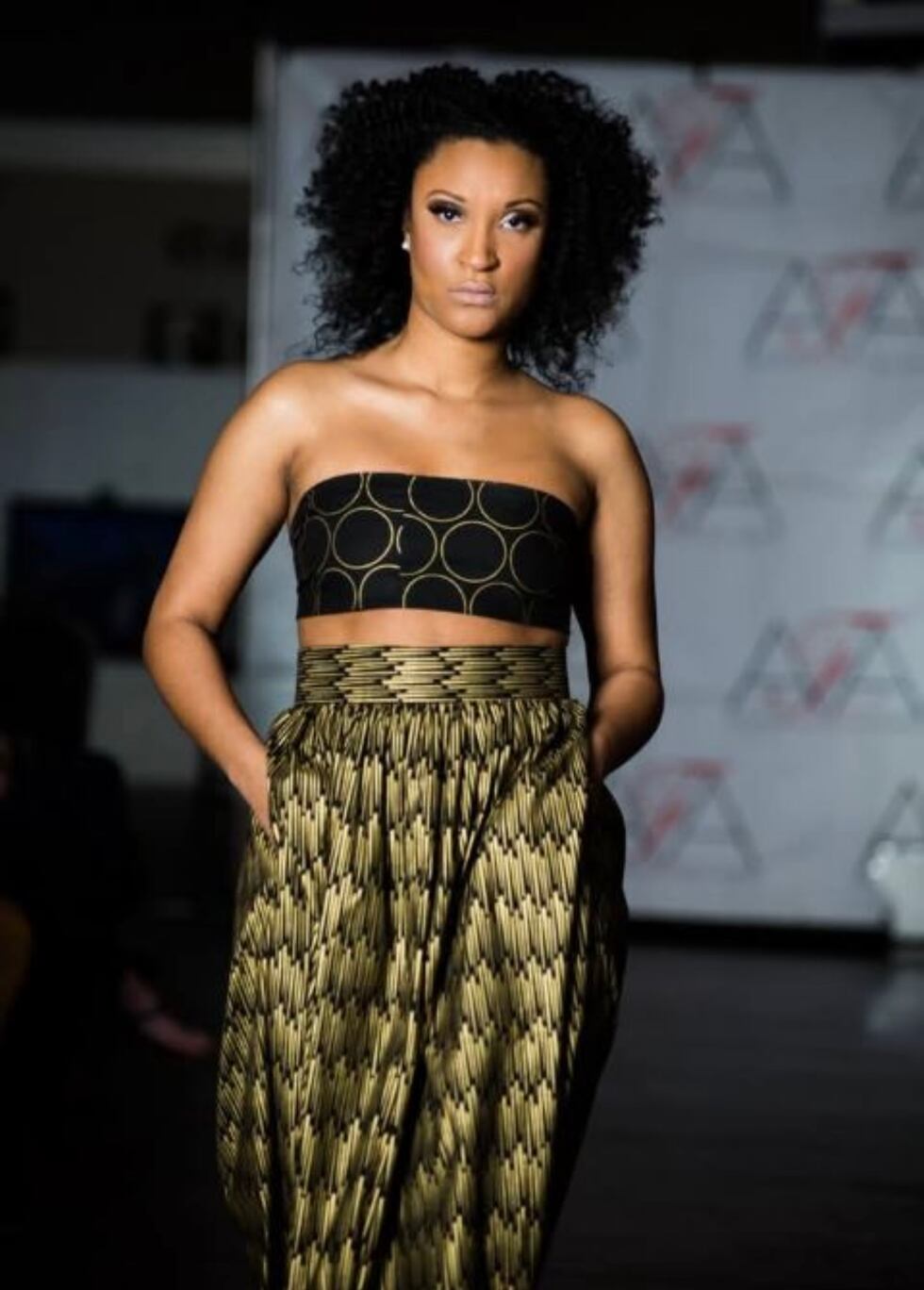 Une femme marchant sur la piste à l'Alabama Fashion Week porte une tenue conçue par Elena Lejoune.