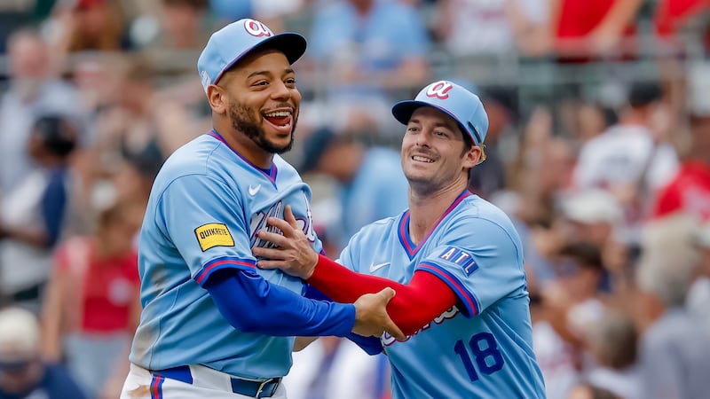 Atlanta Braves' Dominic Smith, left, reacts with teammate Mike Yastrzemski, right, after the...