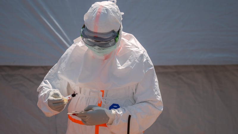 FILE - A health worker prepares a patient's blood sample for testing at Bunia General Hospital...