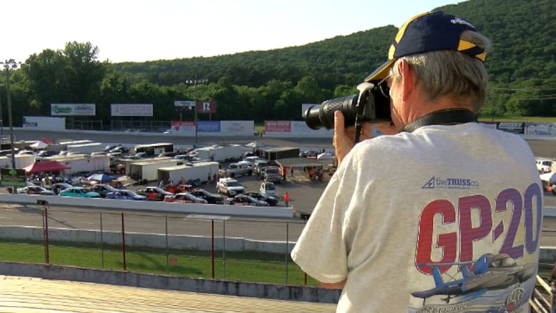 A Huntsville Speedway fan takes pictures during a race Saturday June 3, 2023